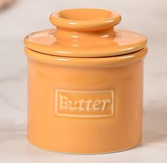 an orange butter jar sitting on top of a counter