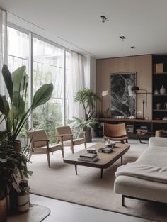 a living room filled with lots of furniture and plants on top of the tables in front of large windows