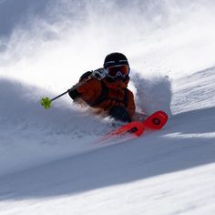 a man riding skis down the side of a snow covered slope