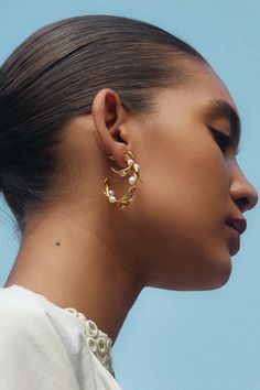 A whimsical take on the classic hoop earring. 18k gold plated leaves and glowing freshwater pearls create an elegant hoop silhouette. Perfect on its own or paired with smaller hoops or studs. 18k gold plated sterling silver, white freshwater pearls. 1 1/4" diameter. Handmade in Vietnam.