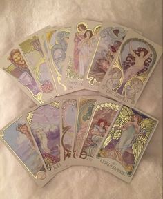 four tarot cards with angels on them sitting next to each other, all in different colors