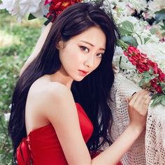 a woman in a red dress holding flowers