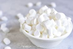 a bowl filled with marshmallows on top of a table