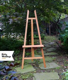 a wooden easel sitting in the middle of a garden