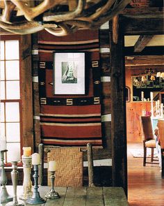 a dining room table and chairs in front of a wooden wall with pictures on it