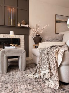 a living room filled with furniture and a fire place next to a wall mounted fireplace