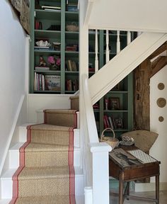 stairs leading up to the second floor with bookshelves on either side and below