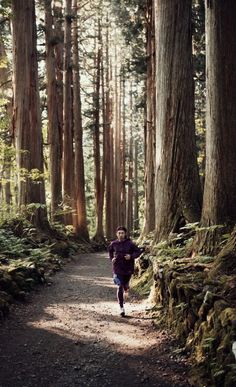 a person running down a trail in the woods