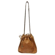 Stunning brown leather Chanel drawstring handbag circa 2011! Brown leather is embossed with iconic Chanel camellias which gives this bag such an elegant touch. Featuring brass hardware, a brass and interwoven leather crossbody style chain as the strap, and a brass chord stitching going along the perimeter as the finishing touch. A gorgeous cherry red lining is accompanied by a zip-fastening pocket as well as a slip pocket to ensure all of your belongings remain secure all day. The bag is complet Drawstring Handbag, Chanel Camellia, Hobo Crossbody Bag, Boho Aesthetic, Chanel Vintage, Cherry Red, Brass Hardware, Head Scarf, Missoni