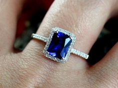 a woman's hand with a ring on it and a blue stone in the middle