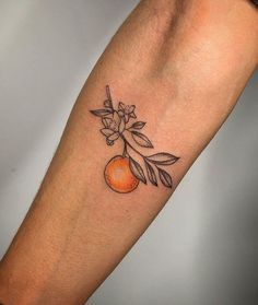 an orange tattoo on the left arm with leaves and flowers growing out of it's center