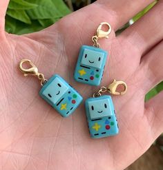 three blue dice shaped key chains in the palm of someone's hand