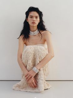 a woman in a white dress is posing for the camera with her hands on her hips