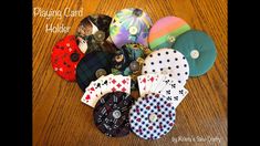 many different colored and patterned buttons on a wooden table with the words playing card holder