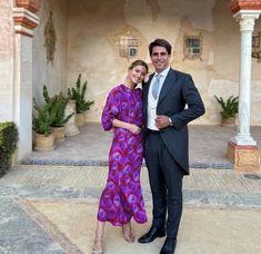 a man and woman standing in front of a building