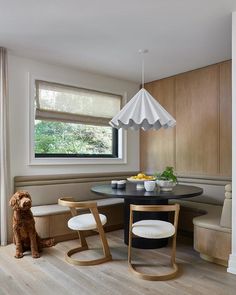 a dog sitting in front of a table with two chairs