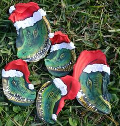 four dinosaur christmas hats laying in the grass