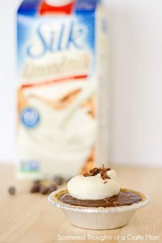 a cupcake sitting on top of a table next to a carton of milk