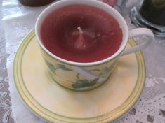 a close up of a cup on a plate with a candle in the middle of it