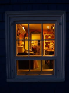 an open window showing the inside of a house at night with light coming through it