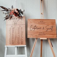 a wooden sign sitting on top of a easel next to a bouquet of flowers