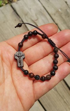 +.God Bless You. +. This is a Wooden Rosary Bracelet. +. It is knotted bracelet and it is adjustable . +. The crufix is carved in elevorate and three dementional shape. +. Beads are more beautiful because they are carved with jujube trees. +.+.+.+.+. Materials +.+.+.+.+.+. Cross: Mpingo (African black wood) beads : jujube tree carved rose wood +.+.+.+.+. Size +.+.+.+.+. Cross : 12mm(Width) *18mm(Height) Beads: 6mm +. Carved characters(e.g. baptismal name, name,etc) on back side +. please send me Adjustable Wooden Beads Spiritual Rosary, Adjustable Crucifix Jewelry With Wooden Beads, Adjustable Wooden Bead Crucifix Jewelry, Adjustable Wooden Beads Rosary Bracelet Gift, Adjustable Wooden Bead Rosary Bracelet Gift, Adjustable Crucifix Spiritual Bracelet, Spiritual Brown Rosary Bracelet With Cross, Gift Rosary Bracelet With 8mm Beads And Crucifix, Jujube Tree