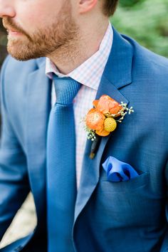 a man in a blue suit with an orange boutonniere