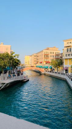 a river running through a city with tall buildings on both sides and a bridge crossing over it