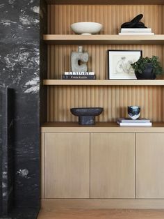 a wooden shelf with books and vases on it