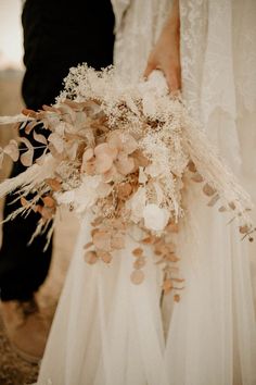 a close up of a person holding a wedding bouquet