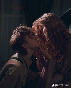 two women kissing each other in front of a piano