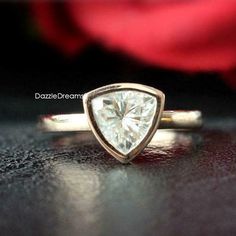 a close up of a ring with a rose in the background