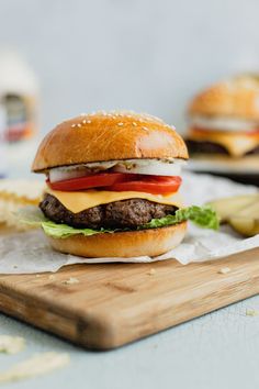 a cheeseburger on a cutting board with fries