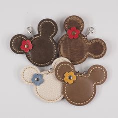 four leather mickey mouse key fobs with flowers on the front and one in the back