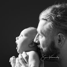 a man holding a baby up to his face