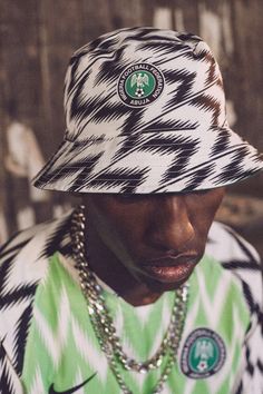 a young man wearing a green and white hat with a starbucks logo on the side