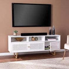 a flat screen tv mounted to the side of a white entertainment center in a living room