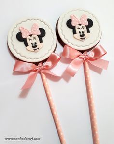 two minnie mouse lollipops with bows on them