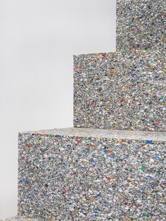 three stacks of different colored rocks on top of each other in front of a white wall