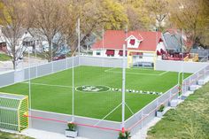 an aerial view of a soccer field in the middle of a neighborhood with houses and trees