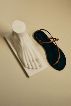 a pair of white feet and sandals on a table