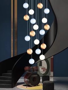 a modern chandelier in the shape of planets hanging from a spiral stair case