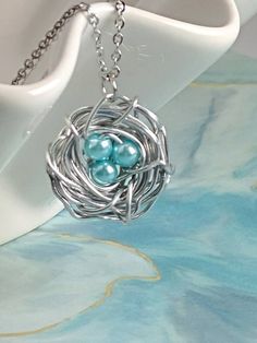 This Bird's Nest necklace is beautiful way to express love of family.  The necklace can be made as seen with 3 robin's egg blue glass pearls OR select birthstone colors as seen in the 2nd to last picture.The size of the nest will measure roughly three-quarters of an inch as seen in the picture, unless you order more than 3 beads, in which case the nest will run a little larger.Each necklace is made to order by me in my workshop.  Only offered in silver tone.  ~~~~~~~~~~~~~~~~~~~~~~~~~~~~~~~~~~~~ Hypoallergenic Round Pendant Necklace For Birthdays, Silver Hypoallergenic Necklaces For Birthday, Hypoallergenic Round Pendant Necklace For Birthday, Cute Silver Jewelry For Gifts, Whimsical Silver Charm Necklace For Birthday, Whimsical Silver Jewelry For Birthday, Cute Silver Necklace Perfect For Mom, Cute Silver Jewelry For Birthday Gift, Cute Blue Necklace For Gift