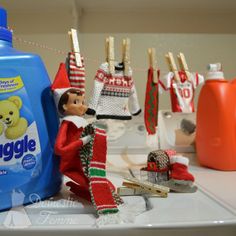 an elf's clothes line up on the counter next to a bottle of toilet cleaner