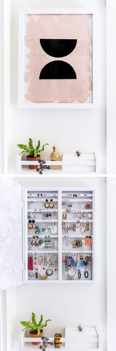 a white shelf filled with lots of jewelry next to a wall mounted art piece on the wall