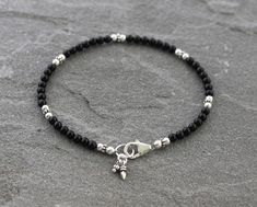 3mm Black Onyx beads are paired with sterling silver accents in this dainty bracelet. Finished with a secure sterling silver lobster clasp and coordinating sterling silver charms. Perfect to wear by itself or with other bracelets for a stacked look. Sterling silver is .925 pure silver. ✧ Message me if you would like this bracelet in a different size. See more Onyx jewelry here: https://www.etsy.com/shop/LindseySilberman?ref=l2-shopheader-name&search_query=onyx Check out other items in my sho Black Bead Bracelet Ideas, Black Bracelet Ideas, Black Beads Earrings, Black Silver Bracelet, Baby Jewelry Gold, Silver Bracelet Designs, Anklet Designs, Black Onyx Bracelet, Black Beaded Bracelets