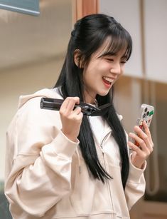 a woman holding a cell phone and smiling