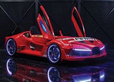 a red sports car with its doors open sitting on a black surface in front of a dark background