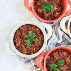 three bowls filled with chili on top of a table