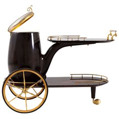 a black and gold serving cart with two trays on it's sides, one holding a coffee pot